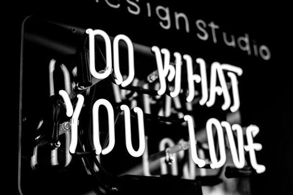 A greyscale photo of do what you love signage