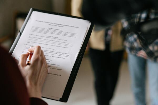 A close-up photo of a person reading a document to other people