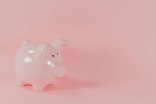 A photo of a piggy bank in a pink background