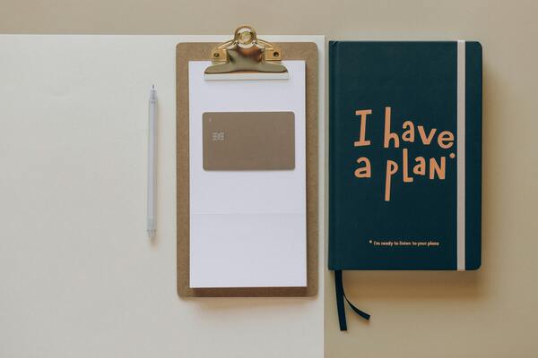 A photo of a notebook with papers beside it