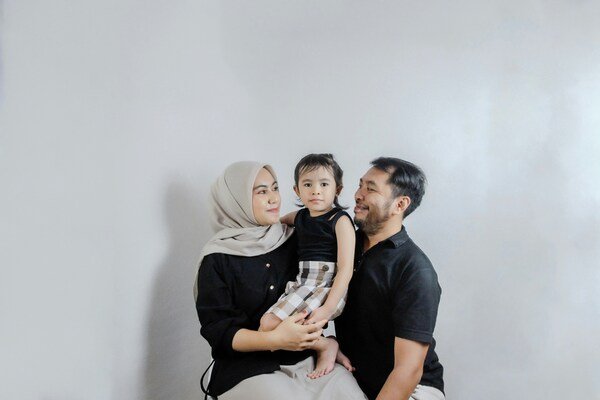 A family photo of a man, a woman, and a young girl child