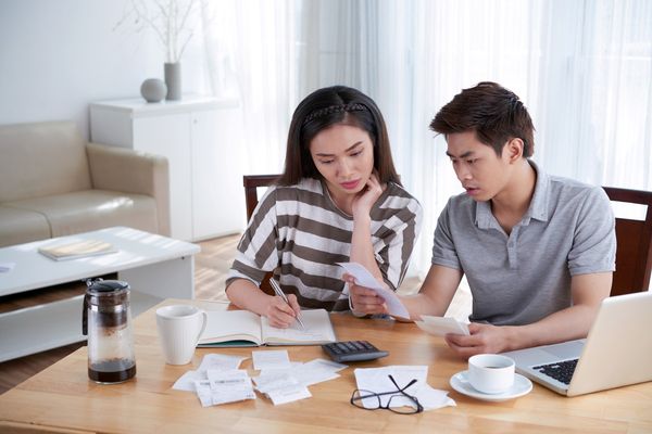 Couple reviewing receipts and expenses before splitting bills 50/50 with partner.