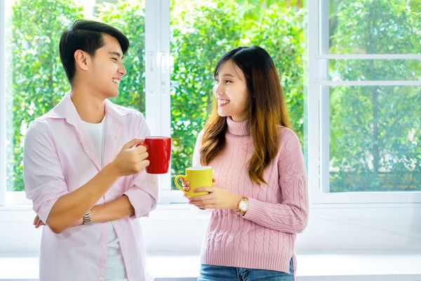Young couple talking over coffee about splitting bills 50/50 with partner.