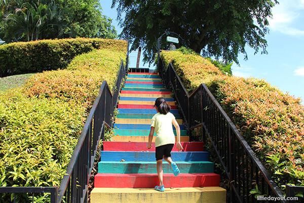 Person climbing the colourful Rainbow Stairs at Fort Canning Park, one of the popular activities in Singapore.