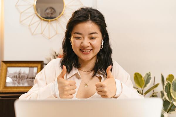 A photo of a woman doing thumbs up hand sign