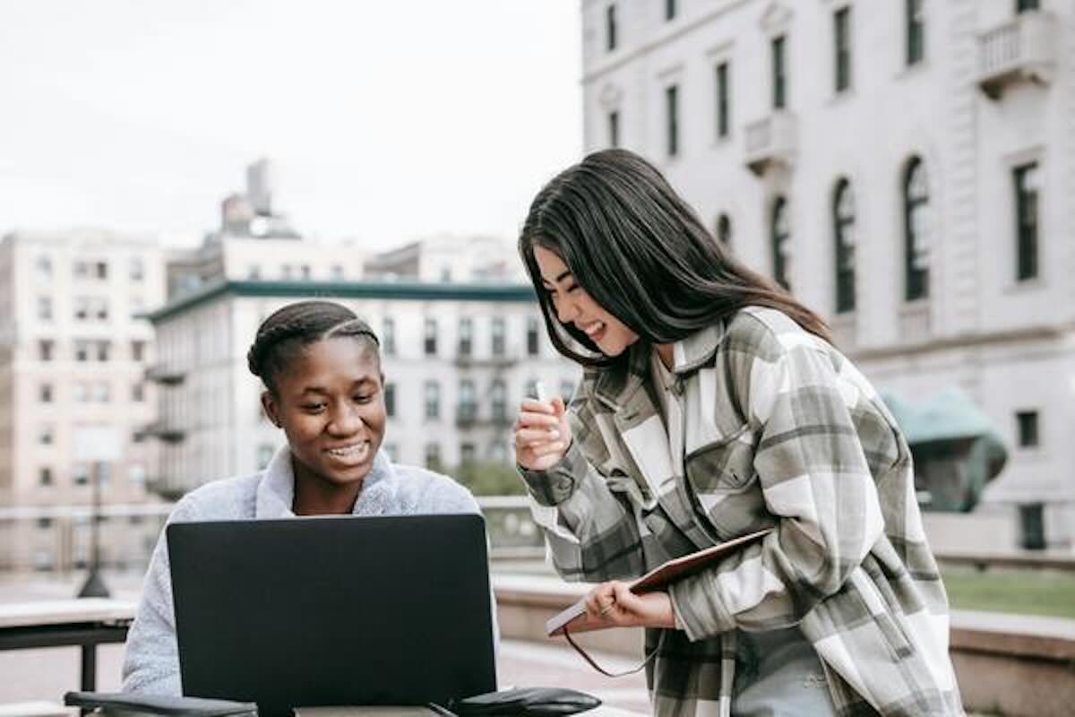 Two remote workers collaborating outdoors while exploring geoarbitrage opportunities.