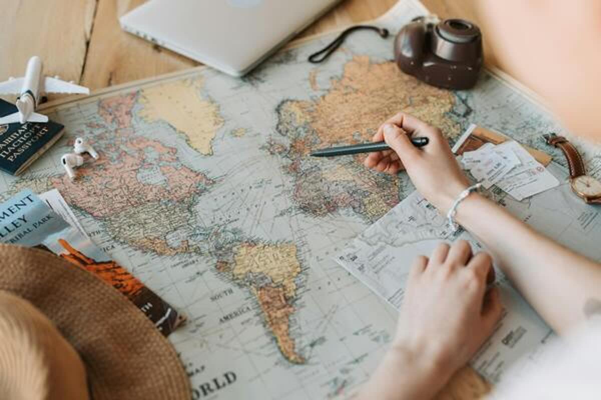Traveller planning destinations on a world map for a geoarbitrage lifestyle.