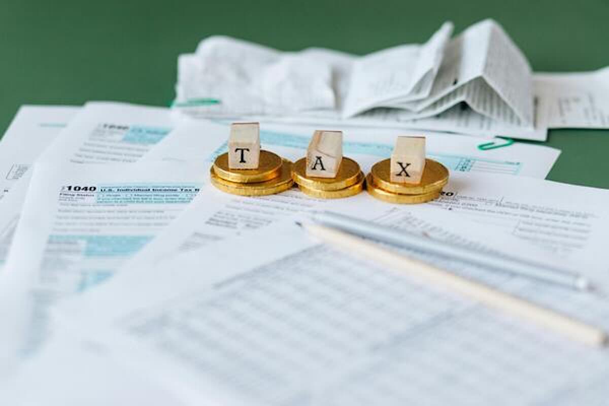 Tax documents and coins highlighting the tax planning considerations of geoarbitrage.