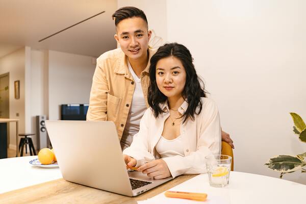 A photo of a man and a woman working together and looking at a laptop