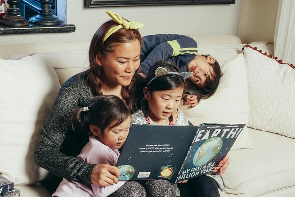 Mother reading a book with her children
