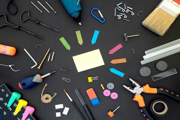 Assorted colour plastic tools on gray wooden table