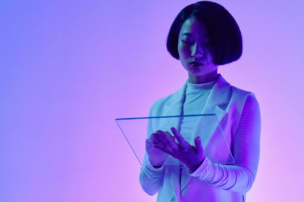 Woman wearing lab gown, holding a digital tablet