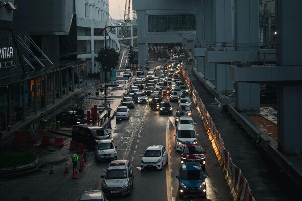 Vehicles stuck in evening traffic in Johor Bahru, with a dusky sky overhead
