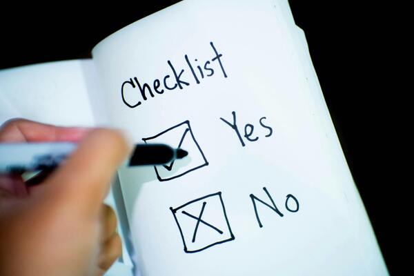 Hand ticking a checkbox in a notebook or workbook