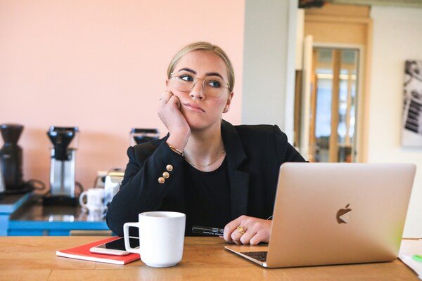 Woman in black long sleeves using a laptop