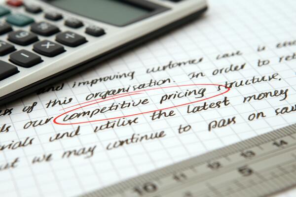 Competitive pricing handwritten text encircled on paper
