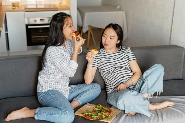Two women eating pizza