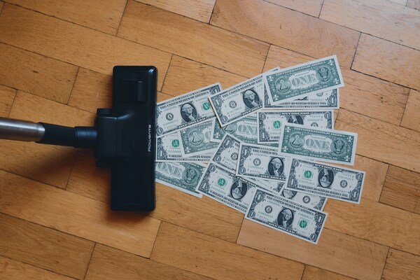 Pile of money on a wooden floor.
