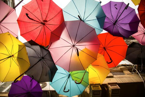Colorful umbrellas viewed from below, creating a bright, patterned canopy.