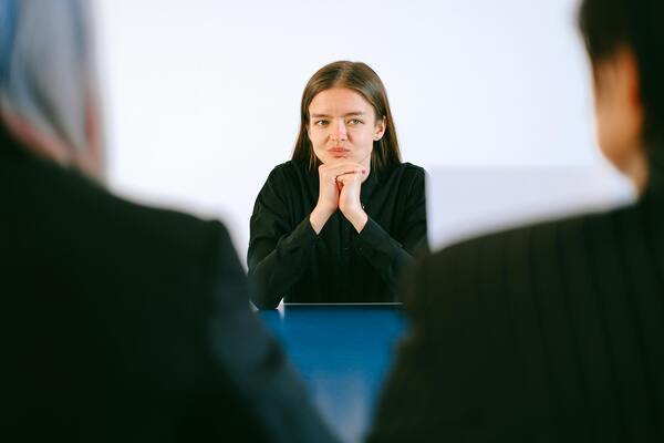 Woman in a black blazer sitting during an interview