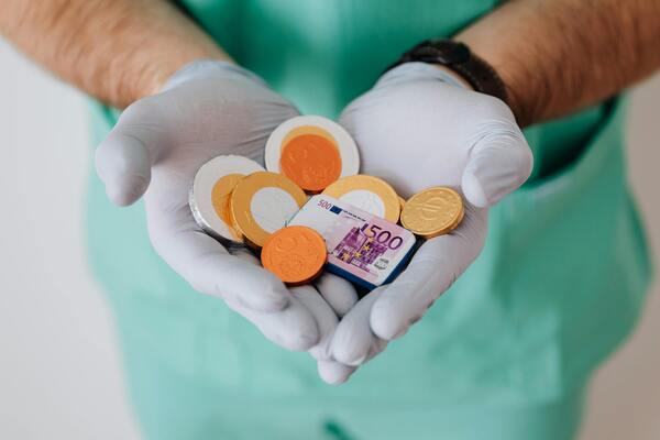 Doctor's hands holding out coins