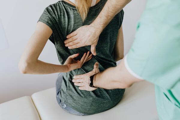 A doctor examining a woman's back