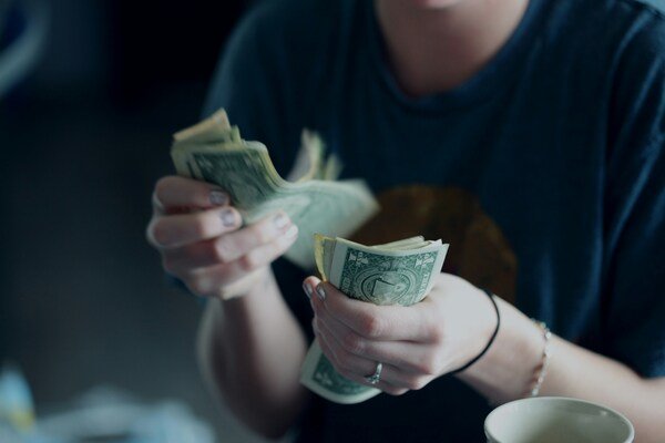 Person counting paper bills in his hands