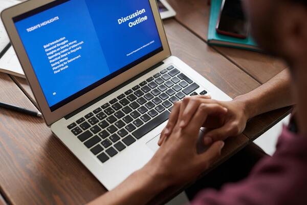 A person sits in front of a laptop.