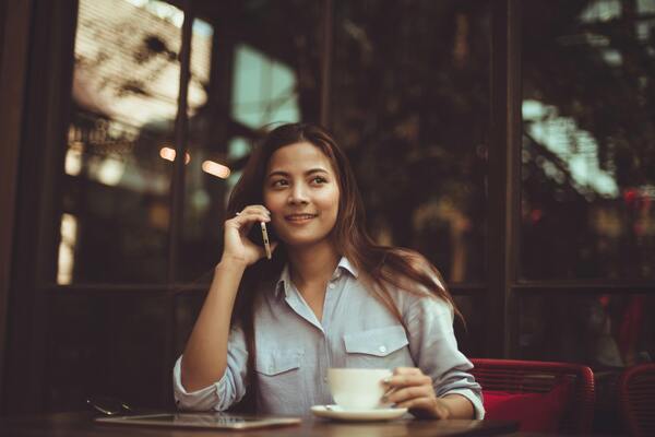 A young woman uses her mobile phone in a café.