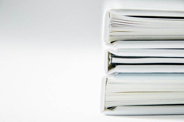 Stack of thick folders on a white surface