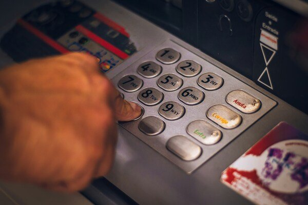 A person's hand using ATM machine