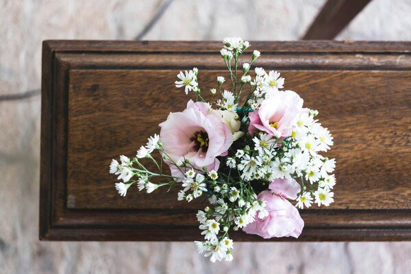 Photo of pink and white flowers placed on top of a casket