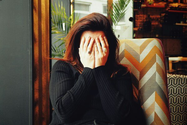 A person covering their face with both hands
