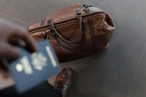 Brown leather duffel bag and a passport