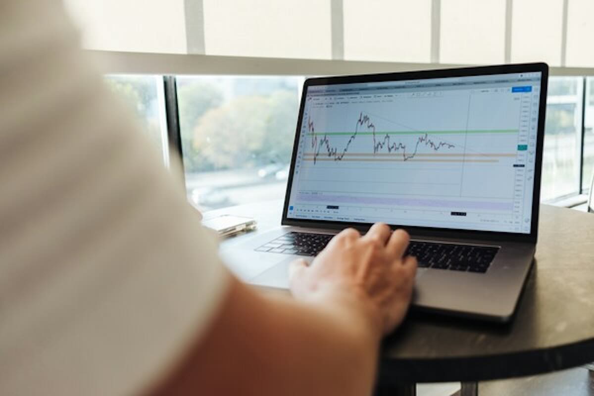 Investor analysing price charts before investing in gold ETFs.