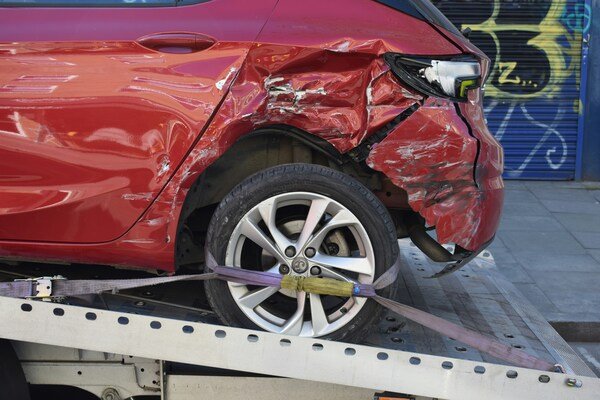 A red car with its front broken after crashed