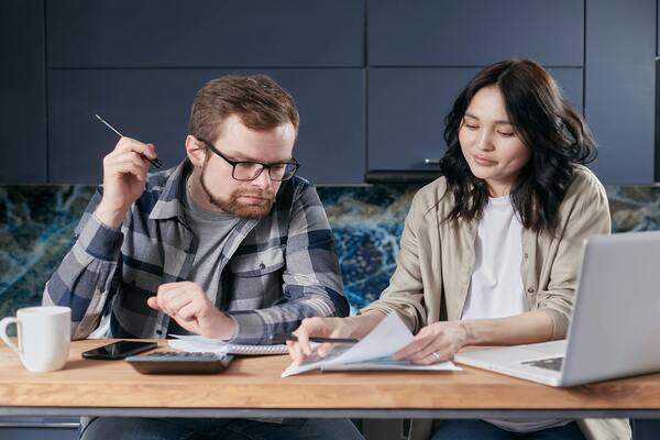 Couple holding up a paper and discussing about retirement planning