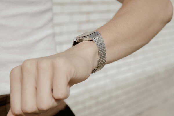 A person's hand wearing a wristwatch