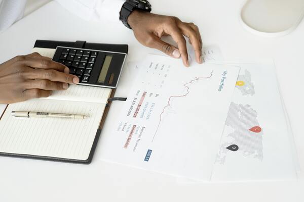 A person's hands checking some documents and calculations