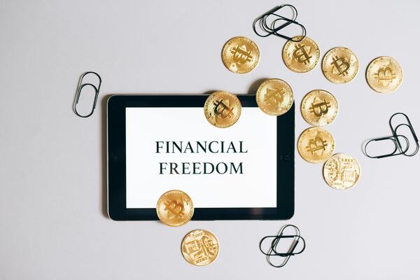A gadget's screen showing financial freedom text with coins and staples around it