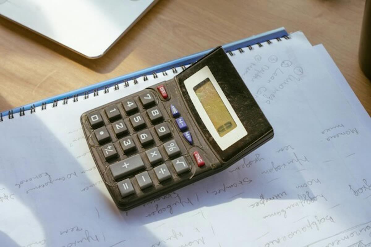 Calculator on financial notes representing an online financial calculator for budgeting and financial planning.