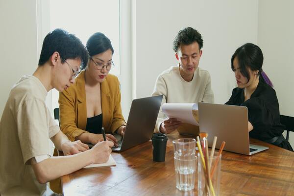 Healthcare professionals and advisors reviewing documents at a table, discussing medical planning and insurance decisions