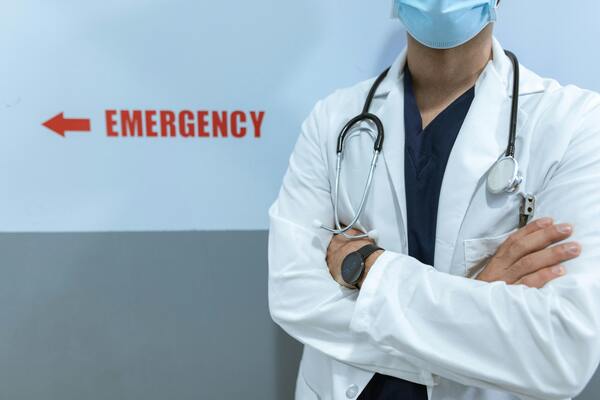 Emergency department doctor wearing a mask and stethoscope, symbolising urgent medical care and hospital services