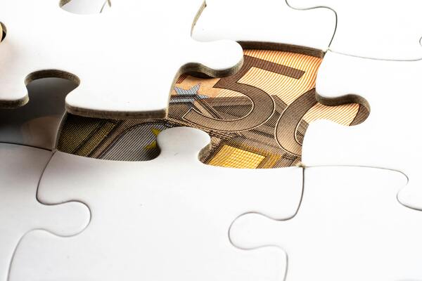 Puzzle pieces revealing money underneath symbolizing financial protection and insurance planning.