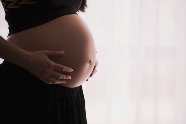 Close-up side view of a pregnant belly, highlighting pregnancy progression after IVF or fertility treatment.