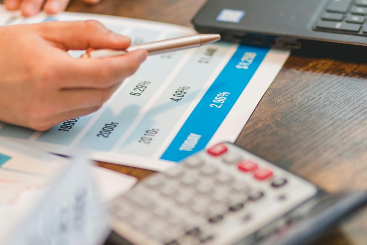 Person reviewing financial data and inflation rates with calculator and laptop