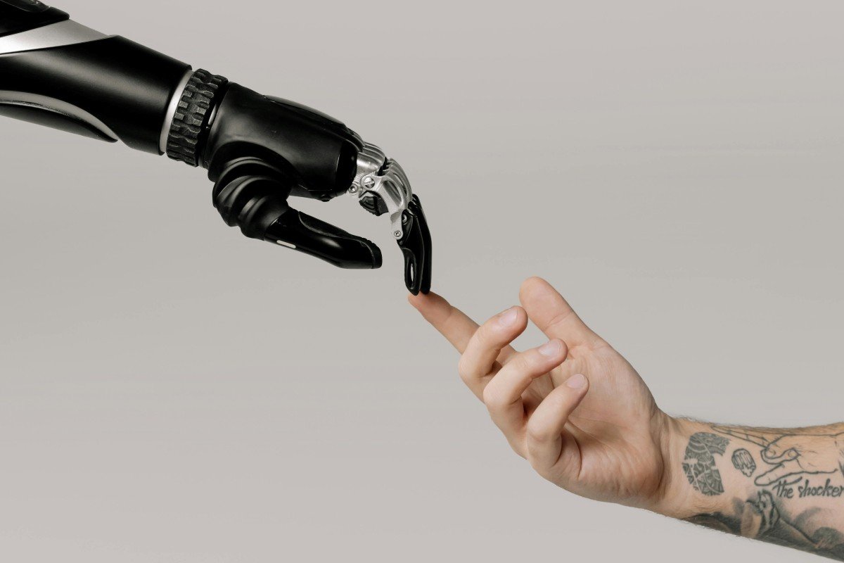 Robotic hand touching human finger to symbolize AI and human interaction