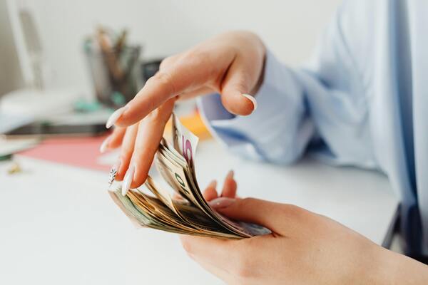 Close-up of hands counting paper currency for budgeting, financial planning, or insurance payments.