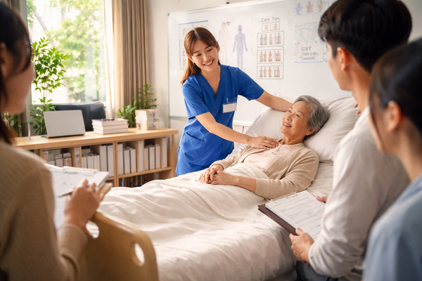Home healthcare nurse caring for elderly woman in bed with family present, professional in-home elder care and caregiver support concept.