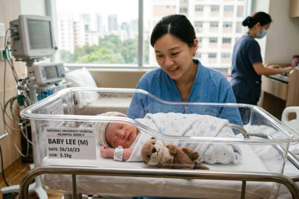A nurse gently cradles a newborn baby in a hospital bed, providing care and support in a medical setting.
